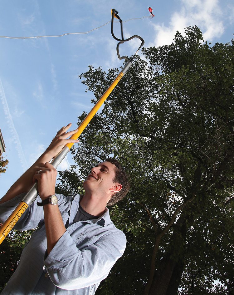 Biology doctoral student Nicholas Smith, shown collecting leaf samples via slingshot, found that including plants’ acclimation to temperature improves climate change models. Photo: Tom Campbell, Purdue Agricultural Communication. 