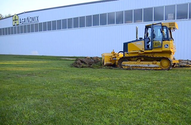 AgriNomix president, Robert Lando, mans a bulldozer to break ground on a new 15,000-square-foot building addition which will increase the company's current operation to more than 70,000 square feet under roof.