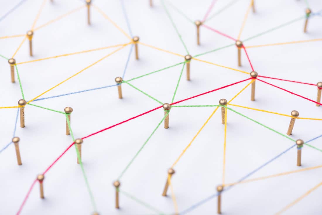 abstract web line connection of color yarn from nail node to node on white background , networking concept