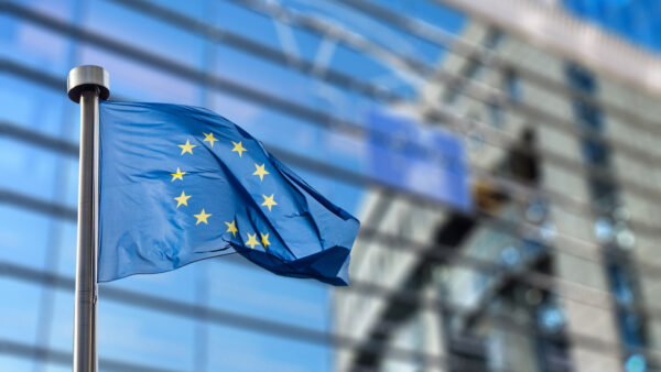 European Union flags in front of the blurred European Parliament in Brussels, Belgium