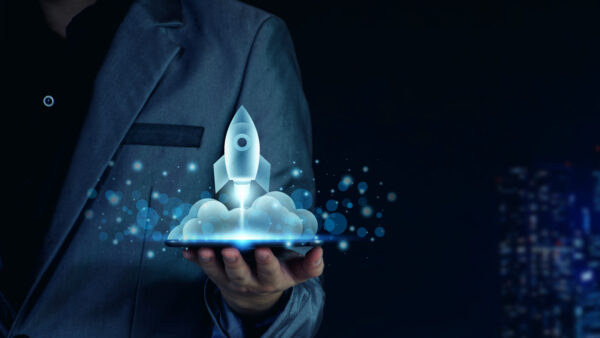 Startup business concept. Businessman holding a tablet, rocket launching and soar flying out from screen, starting a business, growing business, modern technology, hologram, network connection.