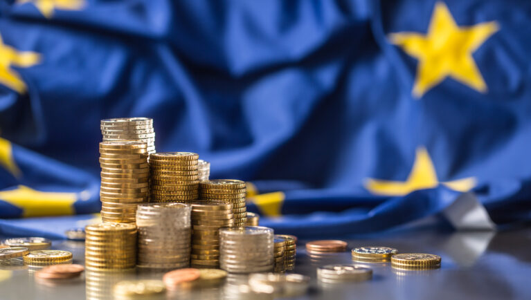 Towers with euro coins and flag of European Union in the background