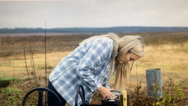 Rachael Sharp inspects irrigation infrastructure on her South Carolina certified seed farm while exploring AI applications for farm management.