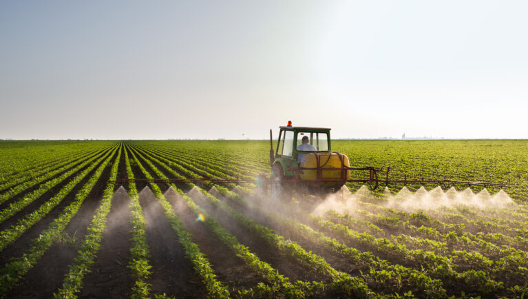 Tractor spraying soybean field